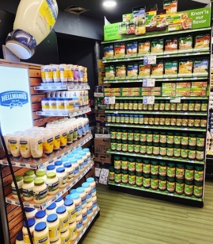 Hellmann's corner display with an illuminated sign beside Knorr-branded shelving in a grocery store