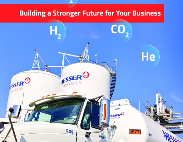 Messer gas storage tanks and tanker truck beneath a red banner promoting industrial gases